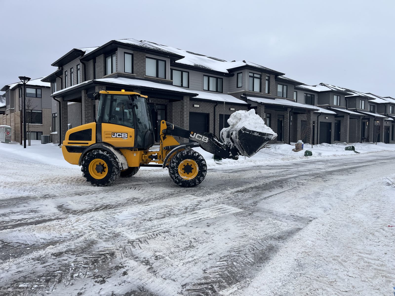 Loader clearing the laneway of a London townhouse complex