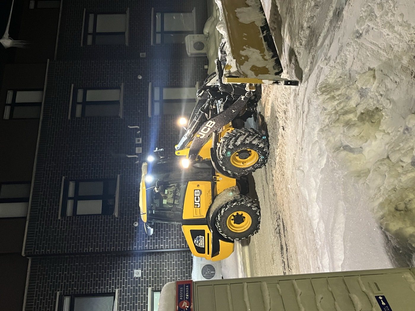 Loader clearing the entrance of a multi-residential building