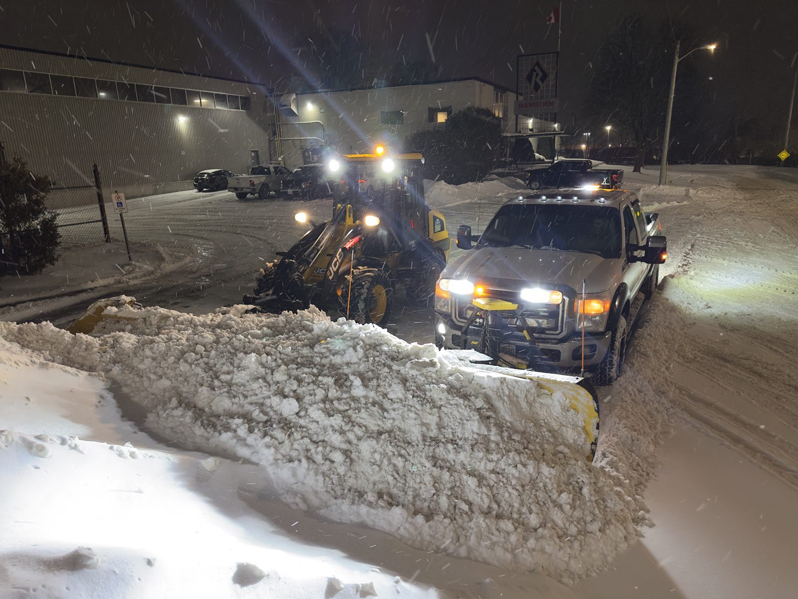 Loader and plow truck working a lot together mid storm