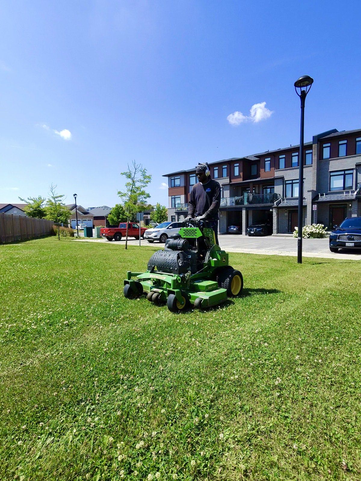 Stand-on mower cutting grass at a London multi-residential property